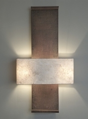 A large architectural wall light Nuit de Chine, by Hannah Woodhouse, is made in aged leather and hand patinated by the artist.  The shade is hand made in eucalyptus paper.